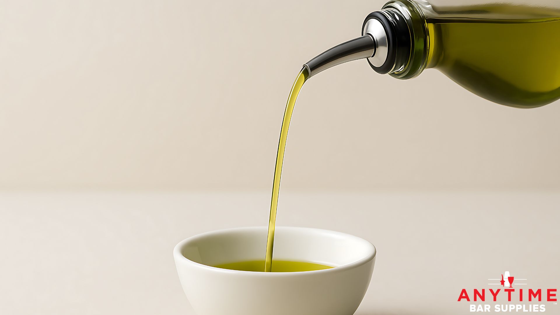 olive oil being poured from a pour spout into a white bowl - Anytime Bar Supplies perfect emulsion